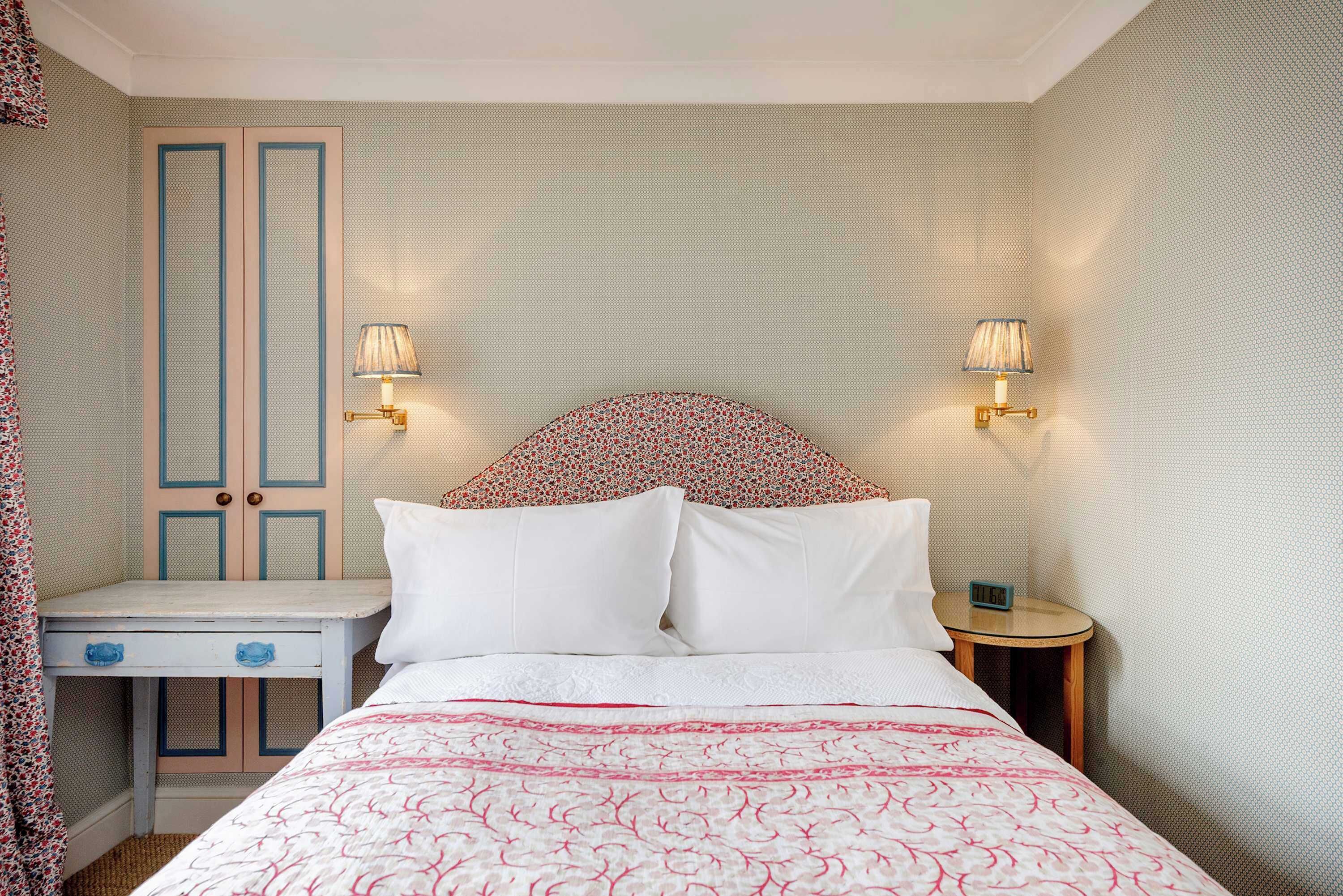 Ein Hotelzimmer mit Bett, Nachttischen, Schreibtisch und Kleiderschrank.