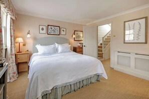 A bedroom with a bed, nightstands, a lamp, a staircase, and framed artwork on the walls. - Gorgeous 3 Bedroom Flat - Pimlico (London)