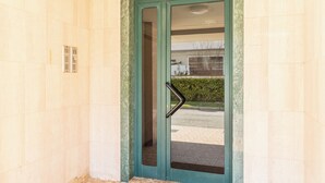 A door with a green frame and a glass panel, leading to an interior space.
