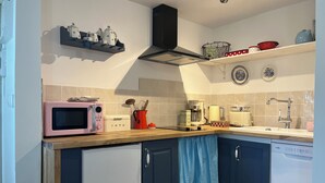 A kitchen with a microwave, coffee maker, and a vintage toaster.