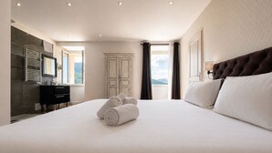 Ett hotellrum med en stor säng, en garderob, en spegel och utsikt över omgivningarna.
