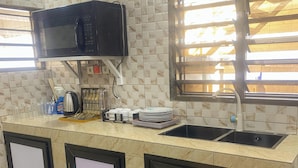 A kitchen with a microwave, sink, and cabinets.