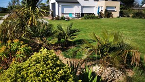 A two-story house with a well-maintained lawn and various plants. - 4.5 km from the beach. Beautiful, quiet house. (Saint-Lormel)