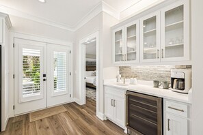 A kitchen with white cabinets, a coffee maker, and a microwave. - Luxury New Build • Steps From The Beach • Pool • Sleeps11 (Destin)