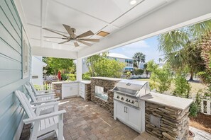 An outdoor patio with a grill, seating, and a view of the neighborhood. - Luxury New Build • Steps From The Beach • Pool • Sleeps11 (Destin)