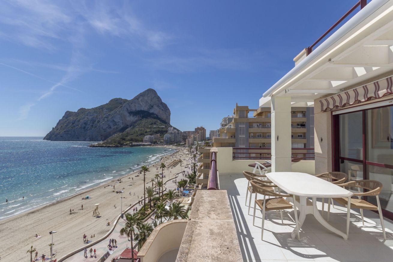 Een balkon met uitzicht op een strand en een berg.