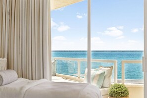 A balcony with a view of the sea, a white railing, and a sofa with cushions. - Best Gulf View • Private Beach • Pool + Hot Tub (Destin)