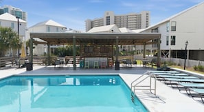 Ein Pool mit überdachter Sitzgruppe und Liegestühlen.