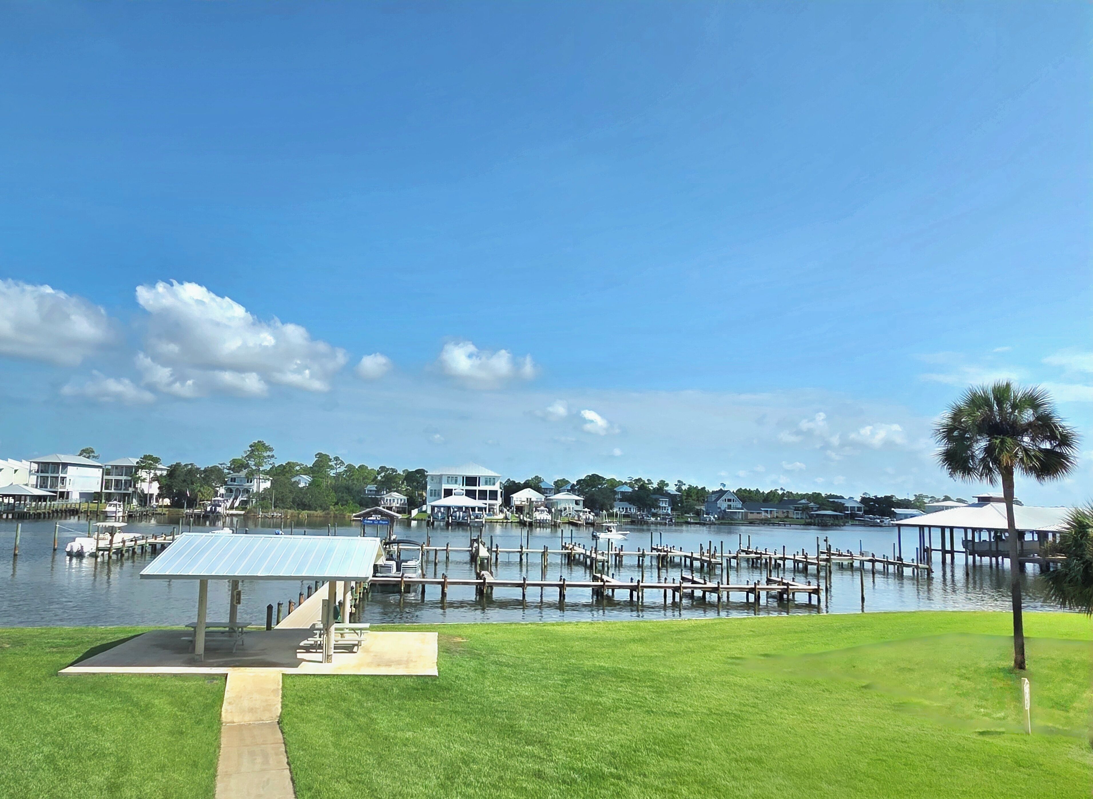 A waterfront property with a dock, a covered pavilion, and a grassy area.