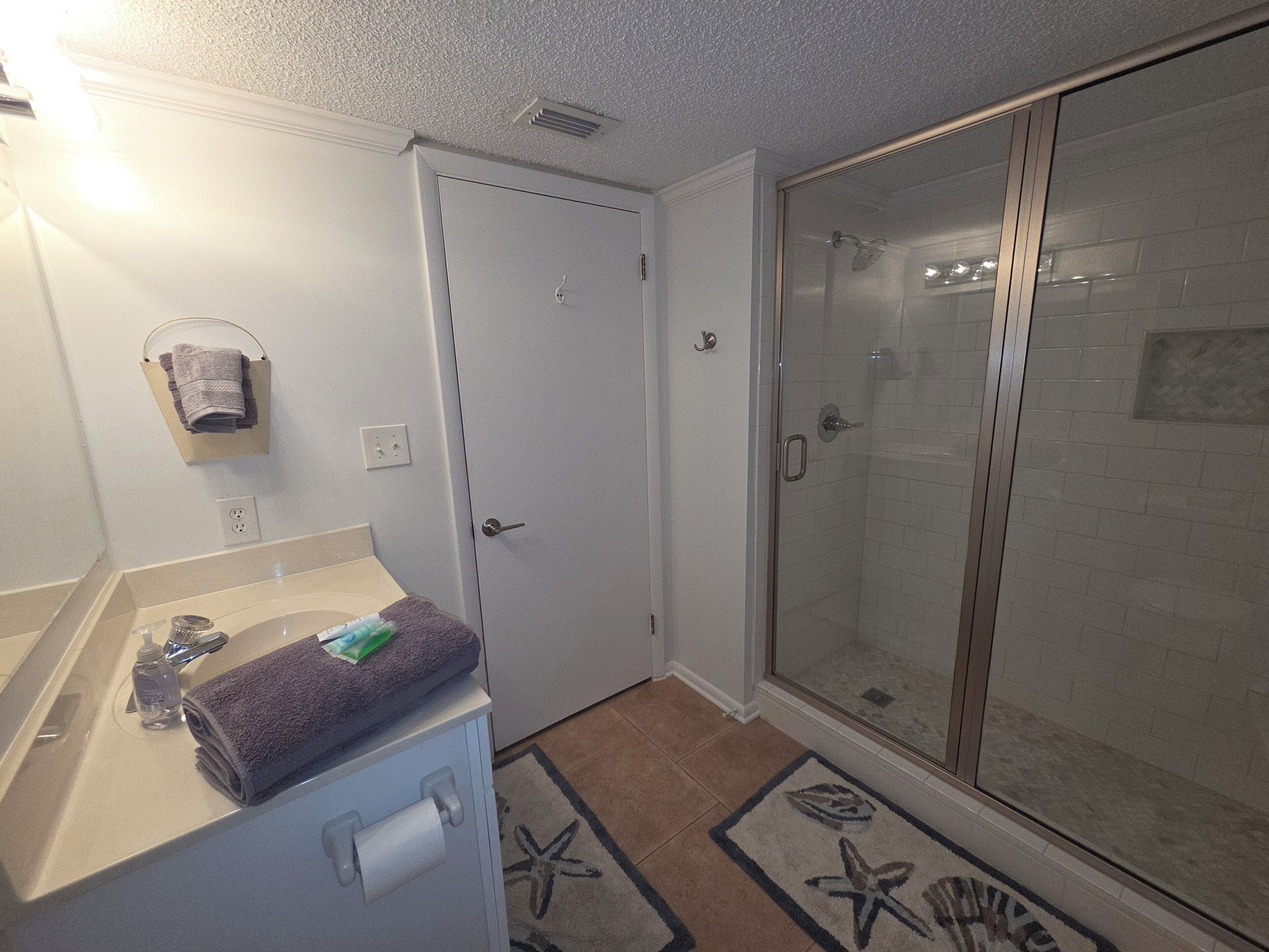 Ein Badezimmer mit Dusche, Handtuchhalter und Toilette.