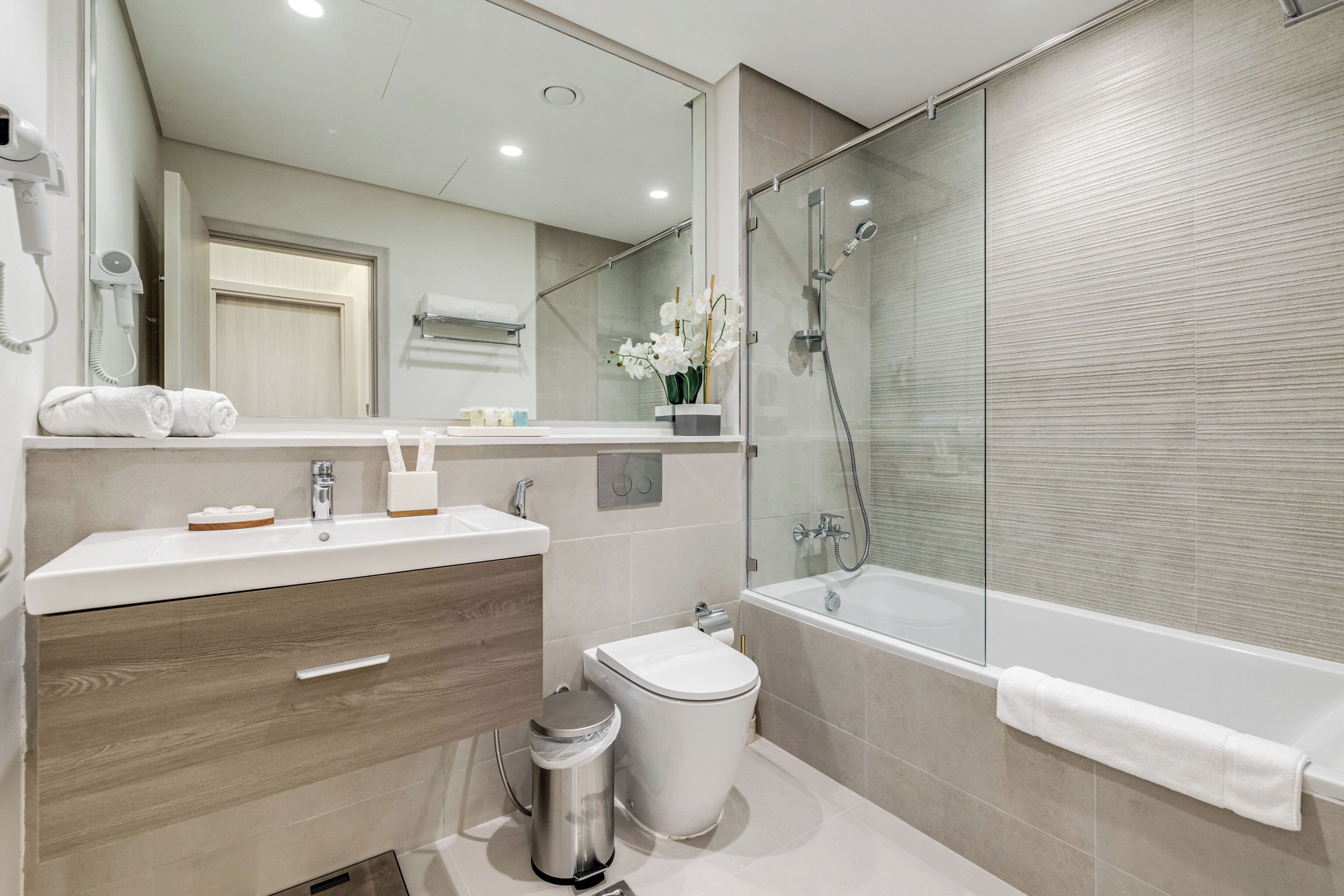 A modern bathroom with a sink, toilet, and shower area.
