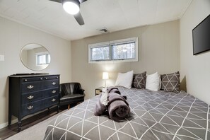 A bedroom with a bed, dresser, chair, and a window. - Harmony Hideaway- Your Perfect Pocono Retreat-Pet Friendly with Hot Tub (Lake Harmony)
