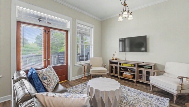 A living room with a sofa, armchairs, a coffee table, a TV, and a fireplace. - Full apartment rental with a balcony downtown. Park and walk to everything. (Ocean Springs)
