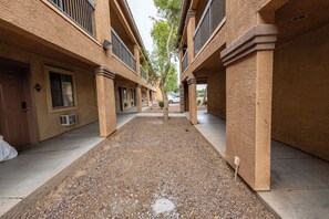 A courtyard with a gravel path, buildings with balconies, and a tree. - New Cozy Studio Fast WiFi & Work Desk (Tolleson)