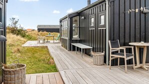 A wooden deck with outdoor furniture, a basket, and a small table. - "Enni" - 350m from the sea by Interhome (Skagen)