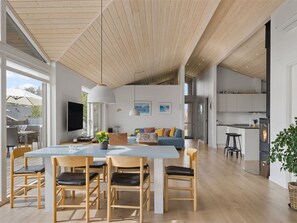 Ein modernes Interieur mit Essbereich, Küche und Wohnbereich.