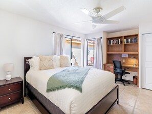 A bedroom with a bed, a desk, a chair, a bookshelf, and a ceiling fan. - Gorgeous 2 BR Condo with Golf Views & Fire Pit (Palm Desert)