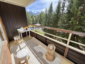 A balcony with a table, chairs, and a wicker basket. - 1st floor, balcony, tv, ski locker, 20m², Vars (Vars)