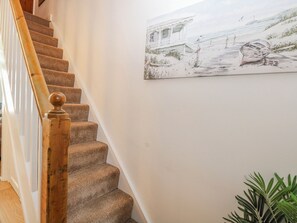 Eine Treppe mit Holzspindeln und Teppichstufen.