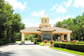 A gated entrance with a covered pavilion, stone pillars, and a small tower. - Ridgewood Lakes - 3 bedrooms Pool Home with Game Room (Davenport)