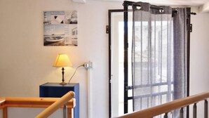 A staircase with a wooden handrail, a lamp on a blue table, and a door with a grey curtain. - Residenza Le Sirene - Holiday Home with Jacuzzi and Terrace near Tropea (Santa Domenica)
