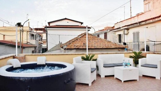 A rooftop terrace with a hot tub, white wicker furniture, and a tiled roof. - Residenza Le Sirene - Holiday Home with Jacuzzi and Terrace near Tropea (Santa Domenica)