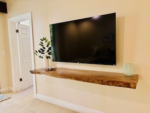 Ein Flachbildfernseher an einer Holzwandablage über einer weißen Tür.