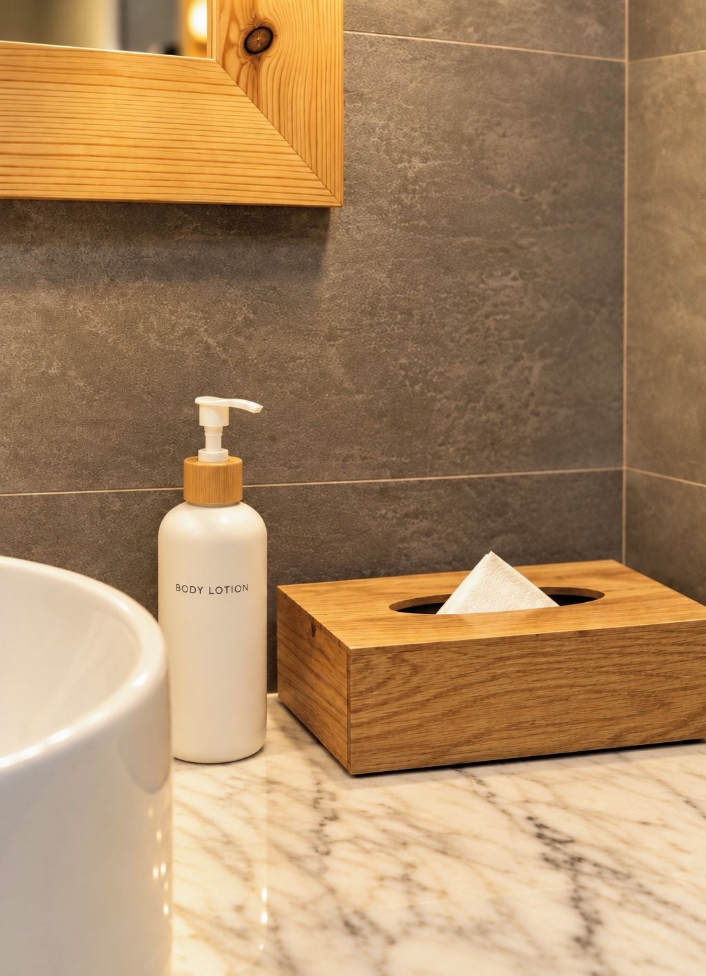 A bathroom with a marble countertop, a wooden tissue box, and a bottle of body lotion.