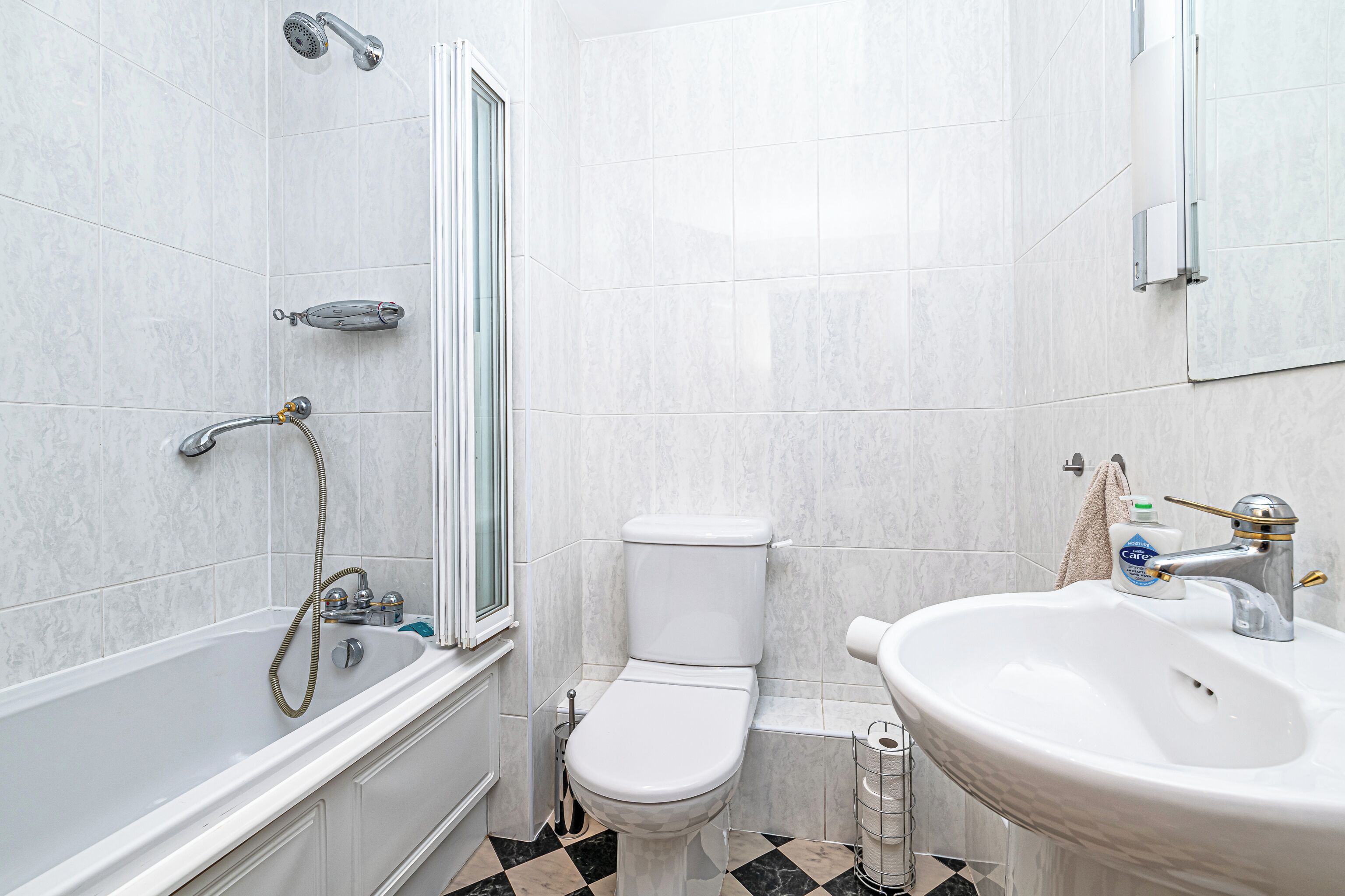 A bathroom with a bathtub, toilet, and sink.