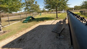 A gravel area with benches and a fence. - "Pooling Around " in Aggieland" (College Station)
