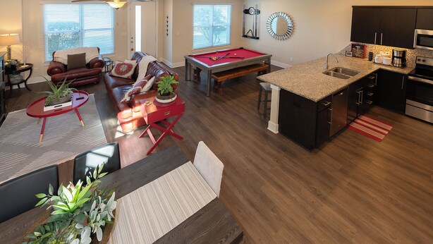 A modern living room with a pool table, a dining area, and a kitchen with a central island. - "Pooling Around " in Aggieland" (College Station)