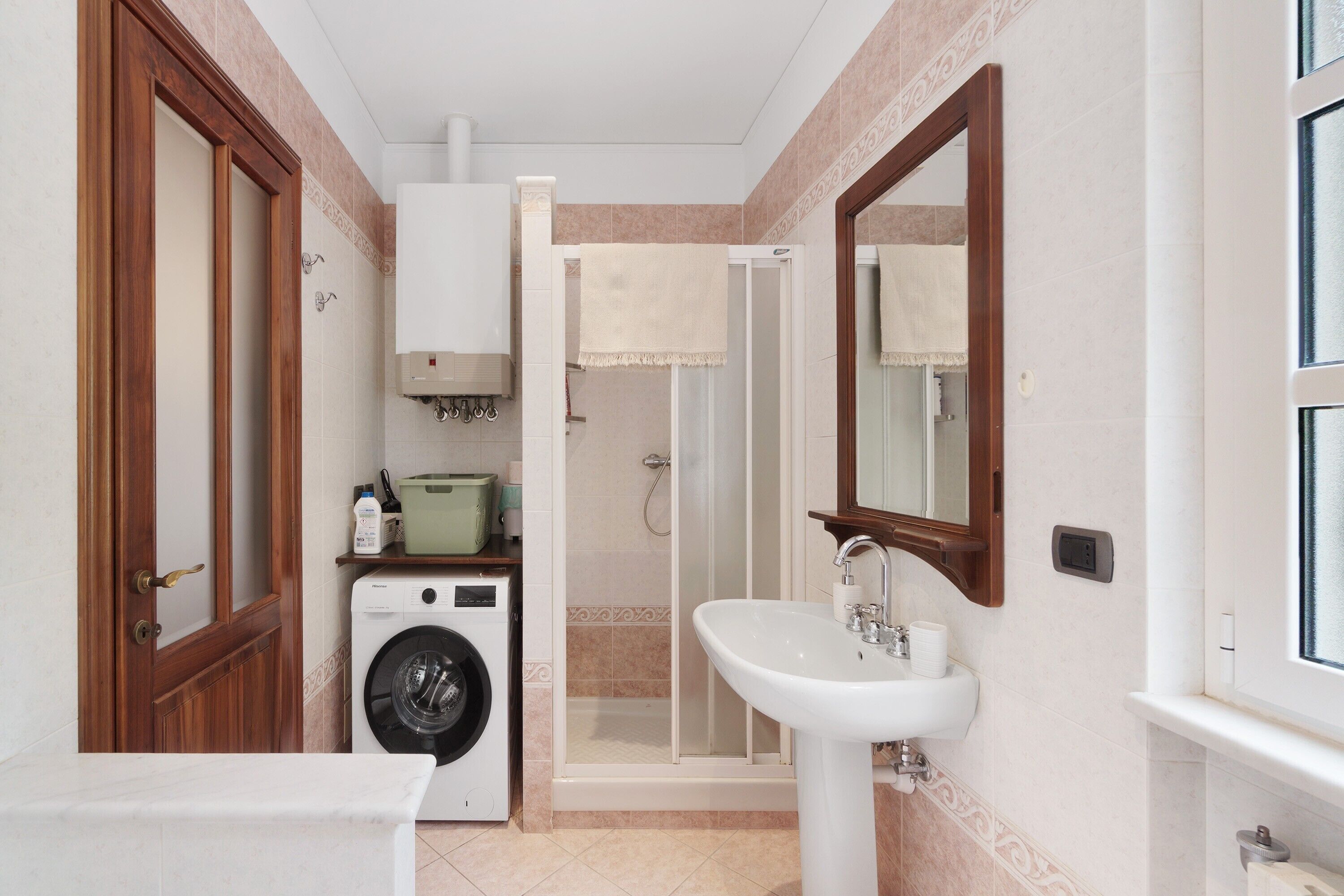 Bany compacte amb rentadora, plat de dutxa i un lavabo.