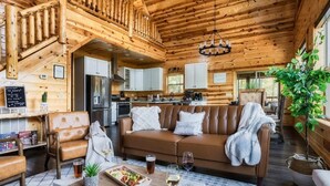 L’intérieur d’un chalet en bois comprend un coin repas, un canapé et une cuisine.