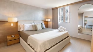 A modern hotel room with a large bed, bedside lamps, a wooden nightstand, a mirror, and a view of the city. - lEPl Luxury&Elegant Apt W/ Ac & Pool Near Provenza (Medellín)