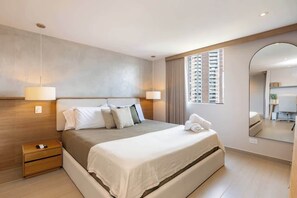 Ein modernes Hotelzimmer mit einem großen Bett, Nachttischlampen, einem Holznachttisch, einem Spiegel und Blick auf die Stadt.