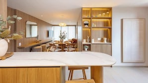 A modern kitchen with a marble countertop, wooden cabinets, and a dining area with a round table and chairs. - lEPl Luxury&Elegant Apt W/ Ac & Pool Near Provenza (Medellín)