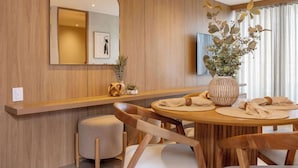 A modern dining area with a wooden wall, a round table, and chairs. - lEPl Luxury&Elegant Apt W/ Ac & Pool Near Provenza (Medellín)