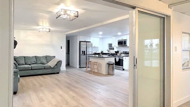 Un intérieur moderne comprenant une cuisine, un coin repas et un salon avec un canapé.