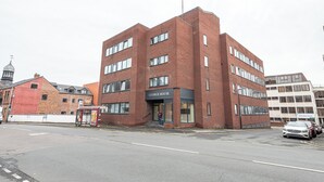 Un edificio in mattoni di più piani con un cartello che riporta la scritta "George House".