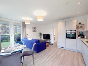 A modern apartment with a dining area, living room, and kitchen. - Luxury One Bed Apartment Near Olympic Park (Greater London)