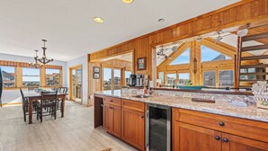 A spacious kitchen with wooden cabinets, a granite countertop, and a large island.