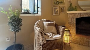 Een gezellige woonkamer met een open haard, een potplant en een comfortabele zithoek.