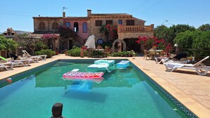 A pool with lounge chairs and a statue, surrounded by a building with stone walls and a tiled roof. - Villa can Juanito- Paradise location, very close to the harbor, Porto Cristo beach (Porto Cristo)