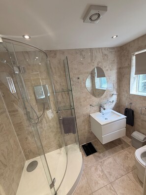 Een aparte badkuip en douche, een diep bad, handdoeken