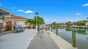 A waterfront property with a dock, outdoor seating, and a clear view of the water. - Beautiful 2-bedroom house with Dock in Key Colony Beach (Key Colony Beach)