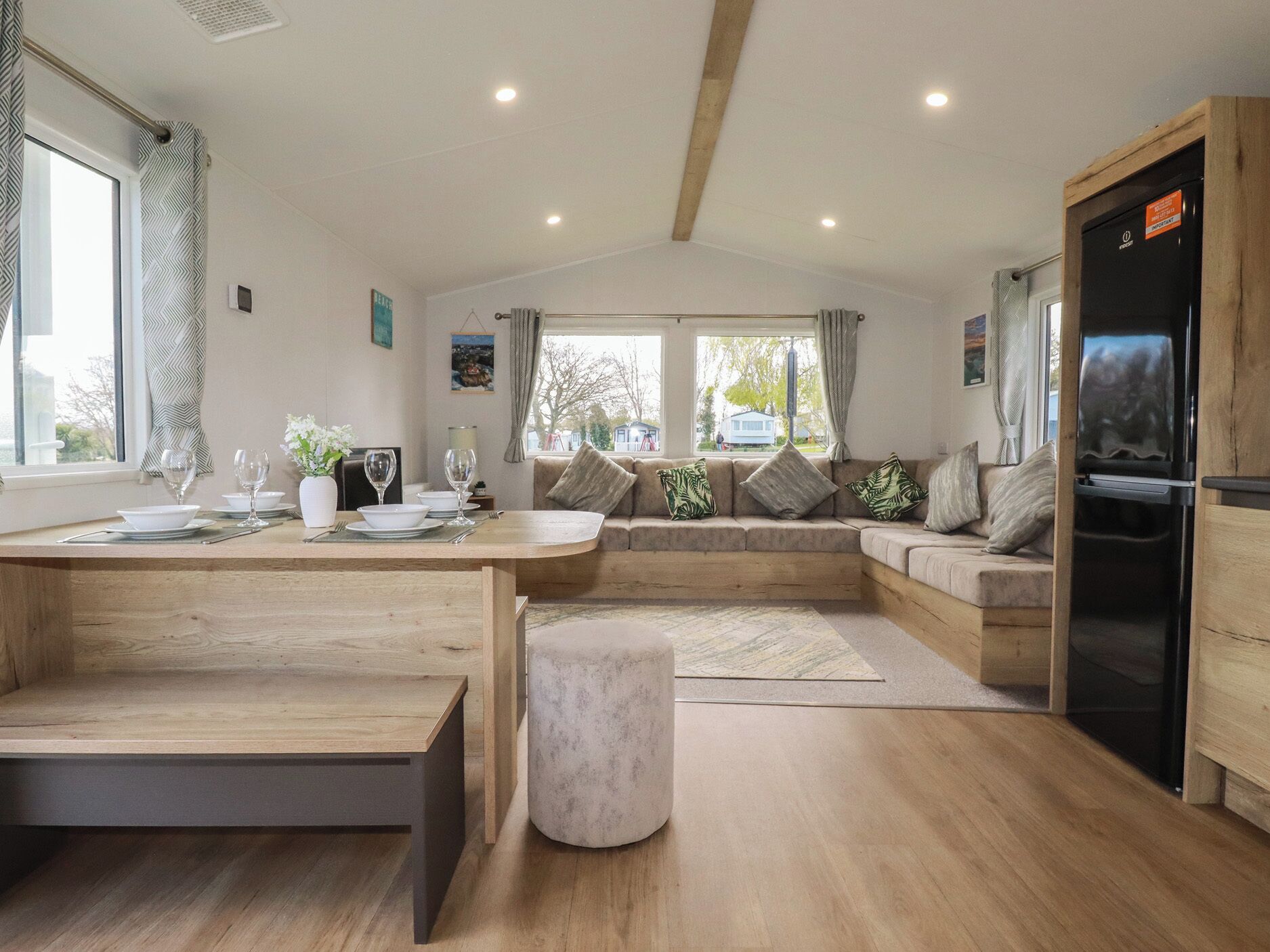 A modern kitchen with a wooden countertop, a built-in oven, and a seating area with cushions.