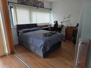 A compact bedroom with a bed, a desk, and a chair. - Charming 2 bedroom apartment in Glasgow. Right next to the SEC and OVO Hydro. (Glasgow)