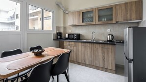 Eine moderne Küche mit Holzschränken, einem Edelstahlkühlschrank, einer Mikrowelle und einem Spülbecken.