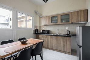 A modern kitchen with wooden cabinets, a stainless steel refrigerator, a microwave, and a sink. - Artemis Coast Stays II - modern cozy apartment, 300 meters from the beach! (Artemis)