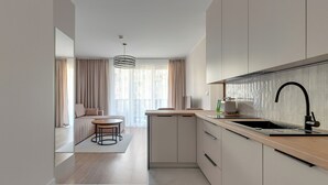 Una cocina moderna con una isla grande, horno integrado y un grifo elegante.